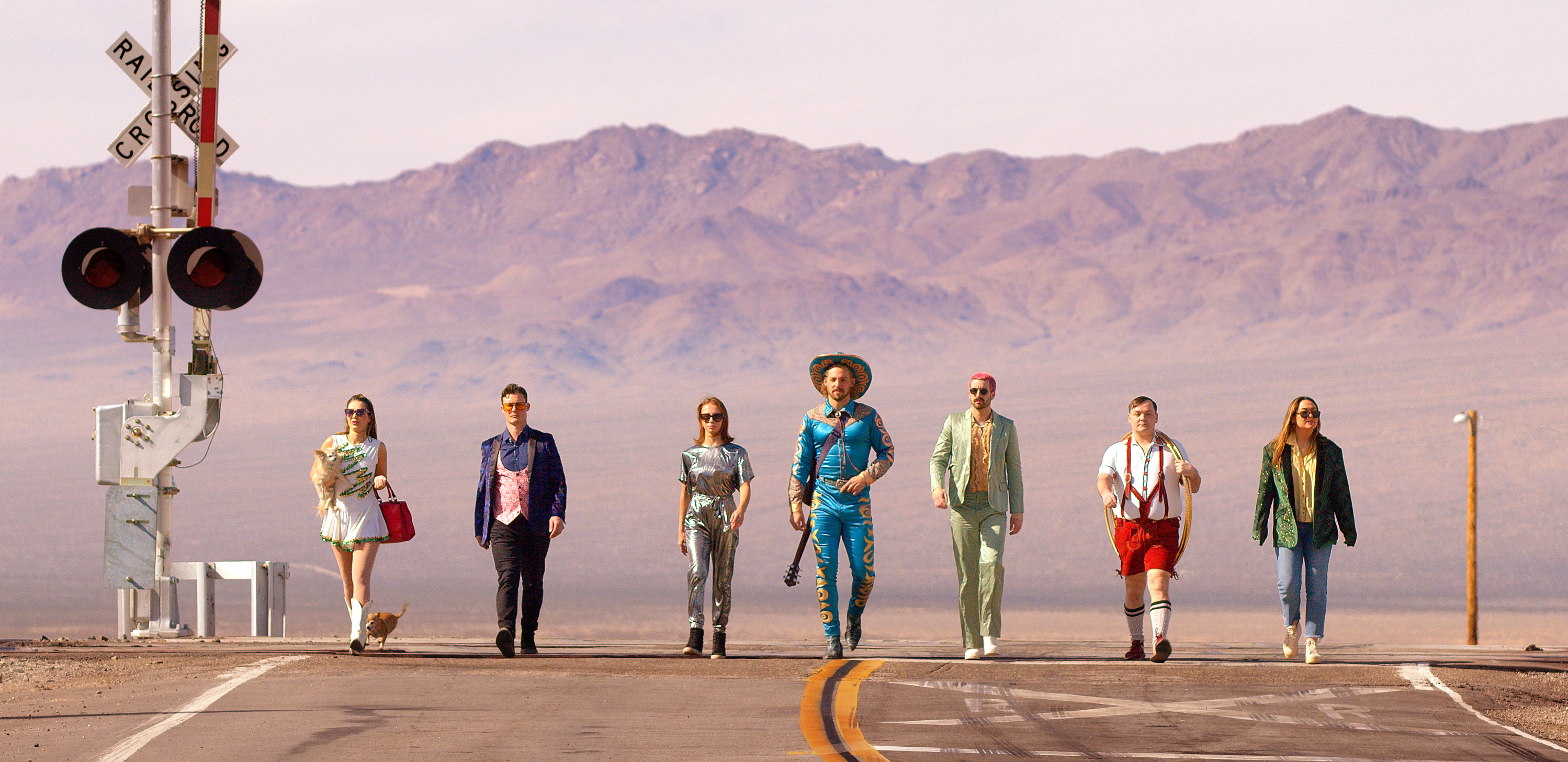 A photo of circus performers walking down a deserted street.